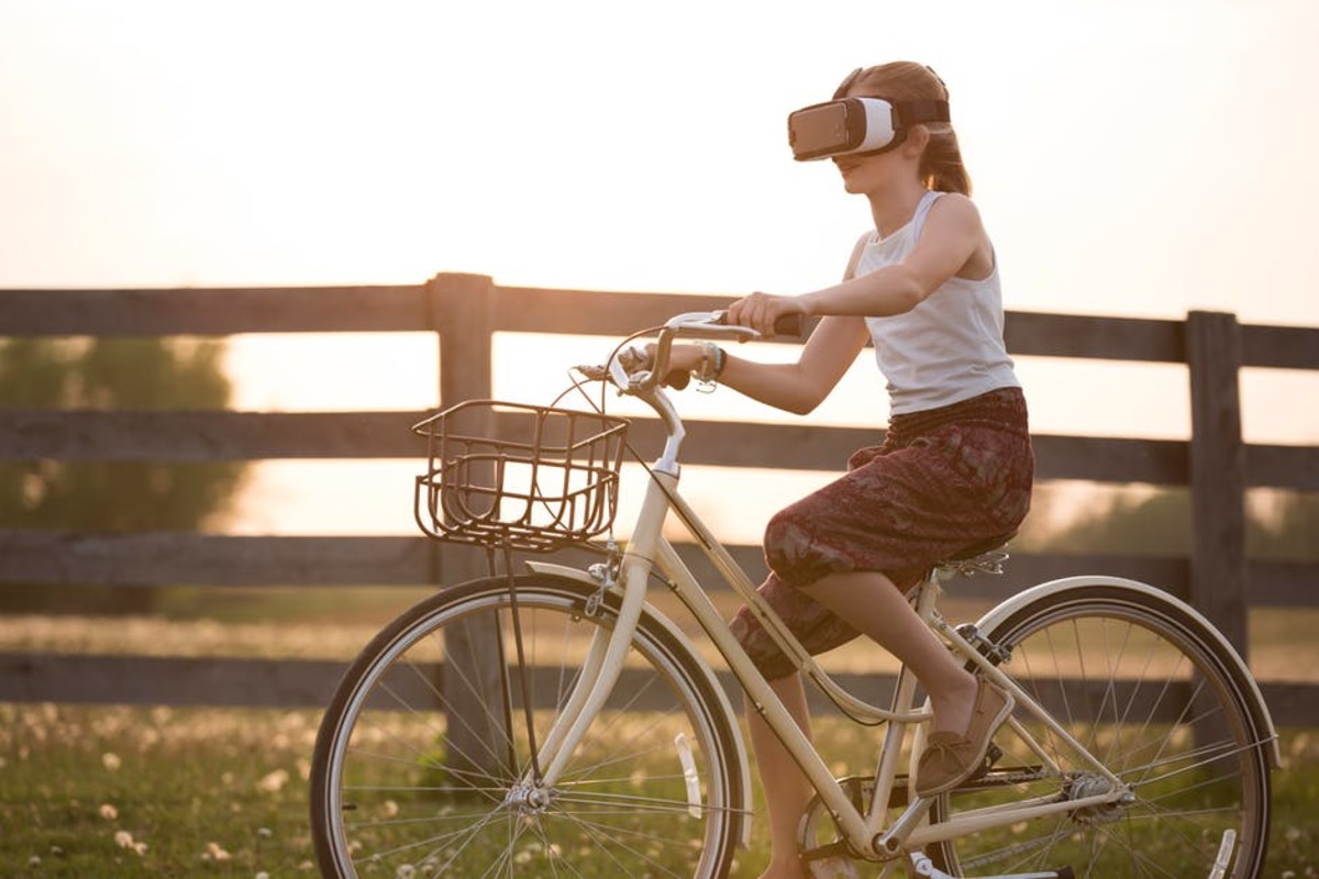 girl riding bicycle wearing VR headset